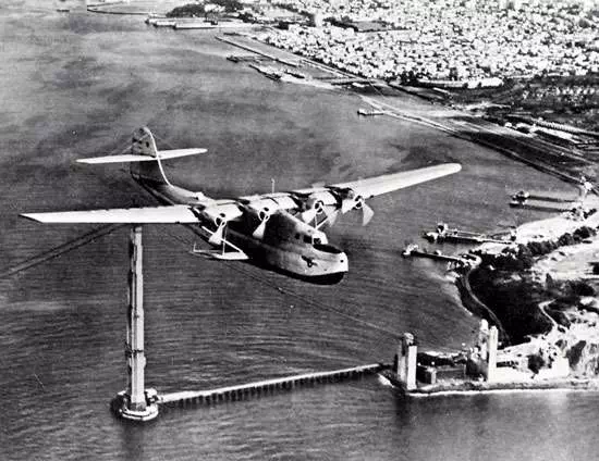 Martin M-130 flying boat, China Clipper, passing over the partially completed Golden Gate Bridge in San Francisco, on its first day of commercial transpacific service, November 22, 1935.