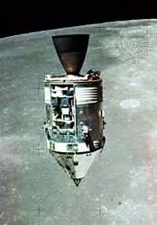 Apollo 15 Command and Service modules in lunar orbit with the Moon's surface in the background, as photographed from the Lunar Module. The Scientific Instrument Module (SIM) bay can be seen on the front of the Service Module.